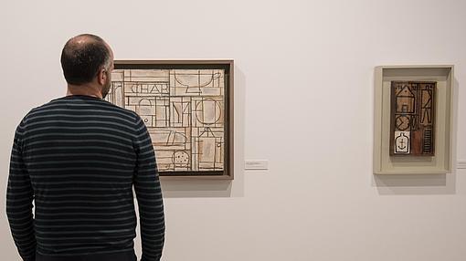 Un hombre contempla dos obras de Torres-García en la exposición