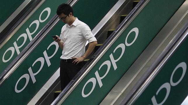Un usuario se desplaza en unas escaleras con la publicidad de Oppo