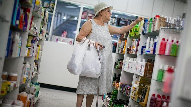 Una mujer busca medicamentos en una farmacia de Caracas