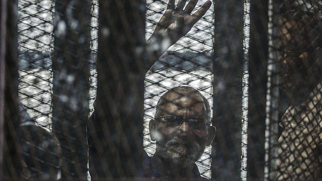 Líder de los Hermanos Musulmanes Mohamed Badie saluda tras las rejas durante uno de los juicios contra la hermandad en El Cairo