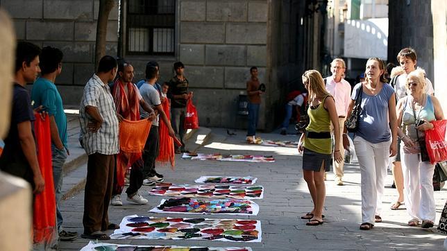 «Manteros» muestran sus productos a turistas en Barcelona