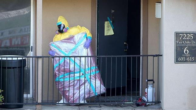 Un operario de limpieza extrae objetos del apartamento donde residió el ciudadano liberiano contagiado de ébola antes de ingresar en el hospital de Dallas