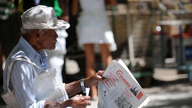 Un vendedor de periódicos sostiene una edición de Granma