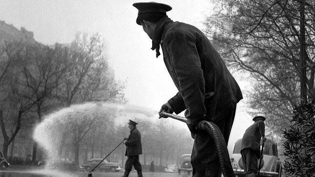 Un trabajador de limpieza usa una manguera en Barcelona