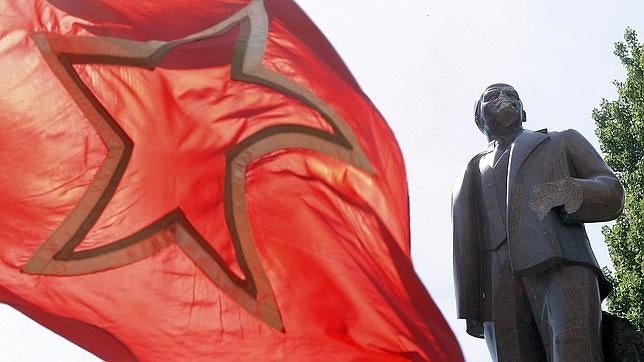 Una bandera comunista ondea junto a laestatua mutilada del líder soviético Vladimir Lenin en Kiev, Ucrania
