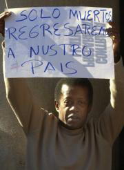 Cerca de medio millar de personas se manifestaron ayer en Valencia contra la Ley; en la imagen, un ecuatoriano despliega una pancarta en la protesta. Efe