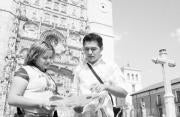 Aremy y Ricardo observan un mapa de Valladolid delante de la iglesia de San Pablo.