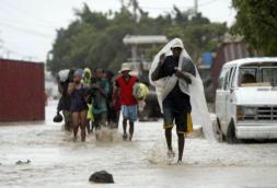 AP Un grupo de residentes de Gonaives, en Haití, huye de sus casas en calles anegadas por las fuertes lluvias causadas por el paso del huracán «Ike»