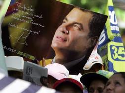 Simpatizantes del presidente ecuatoriano, Rafael Correa , del movimiento Alianza País, enseñan sus carteles electorales. / Efe