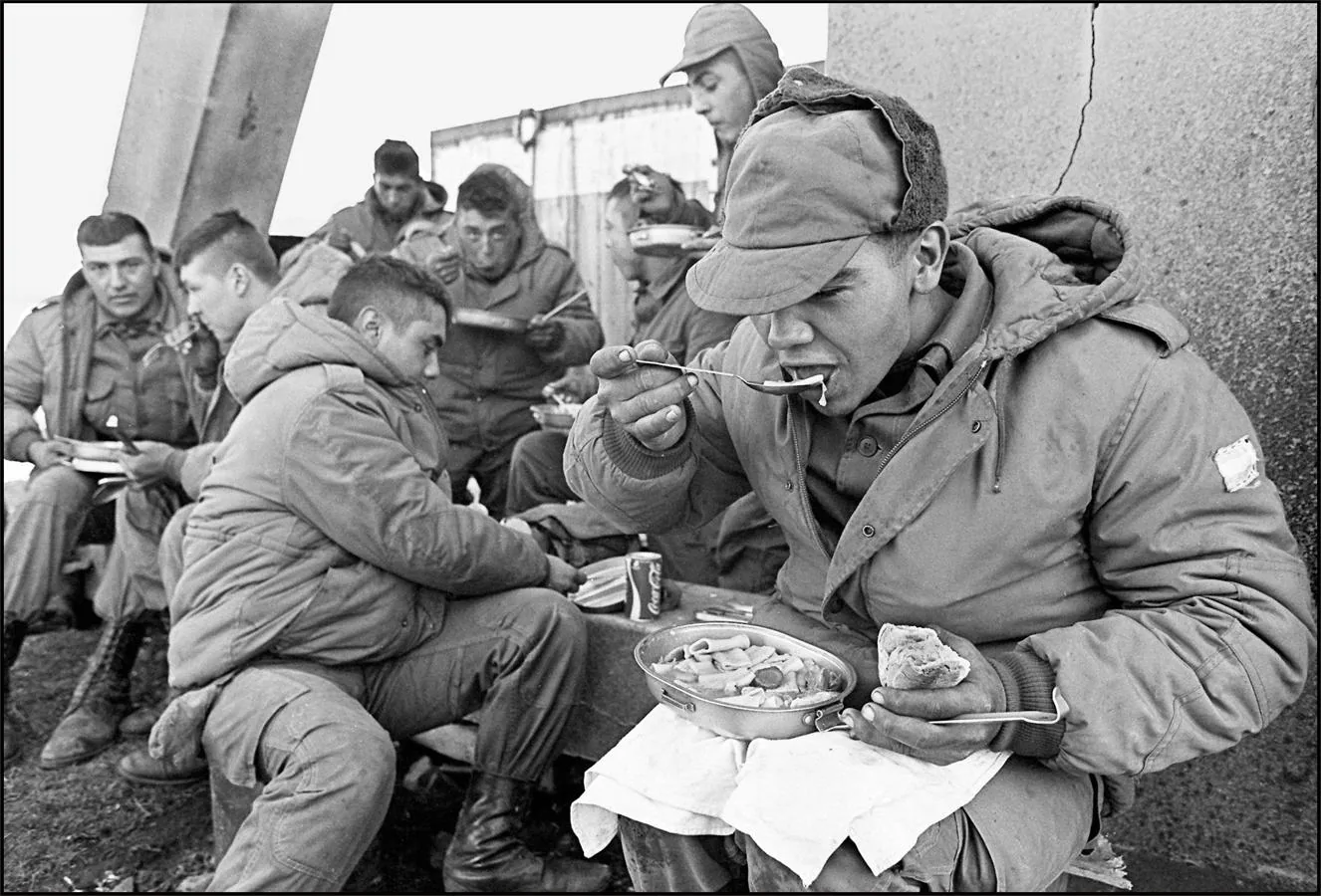 La imagen muestra a los soldados argentinos almorzando en la antigua base de los Royal Marines parcialmente destruida, el 13 de abril de 1982, en Stanley. 