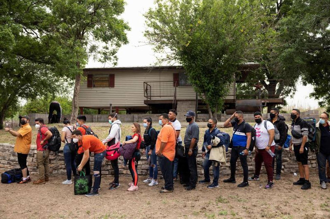 Venezolanos a la espera de ser transportados a un centro de procesamiento