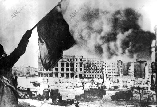 Русские войска доминируют в Сталинграде.  Нацистский флаг перестает развеваться.  Русский солдат показывает его своим товарищам перед командным пунктом 6-й армии.
