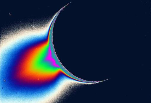 Imagen de la luna de Saturno, Encélado, iluminada por el Sol, tomada por la misión Cassini. La cola de color falso muestra chorros de partículas heladas y agua que se expulsan al espacio desde un océano que se encuentra muy por debajo de la superficie helada de la luna. Las misiones futuras podrían buscar los ingredientes para la vida en un océano en una luna helada como esta