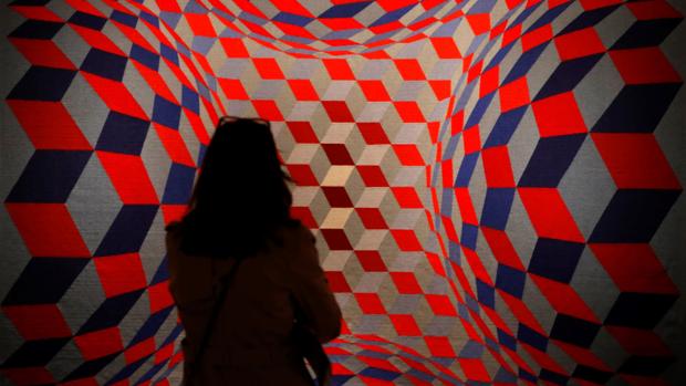 Una mujer admira una obra presente en la muestra