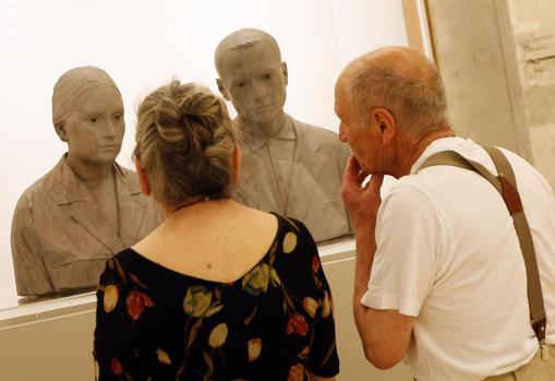 Antonio López y su esposa, MarÃa Moreno, en el Museo Thyssen junto con un retrato escultórico del matrimonio
