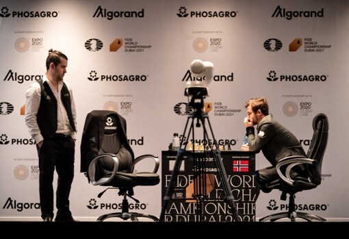 Nepo, de pie, observa a Carlsen en la primera partida del Mundial