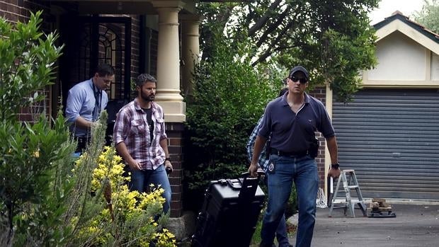 La Policía saliendo de la vivienda del supuesto creador de Bitcoin tras su registro