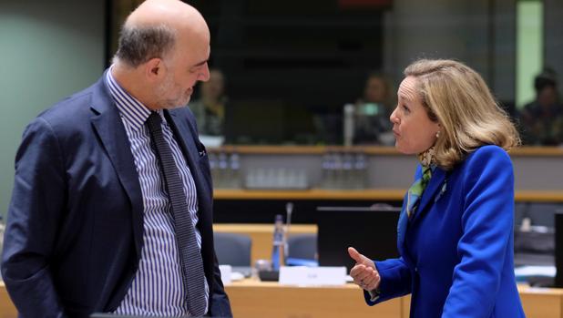 El comisario europeo de Economía y Finanzas, Pierre Moscovici (izq), conversa con la ministra de Economía española, Nadia Calviño, a su llegada a la reunión de ministros de Economía y Finanzas de la UE el pasado mes de marzo