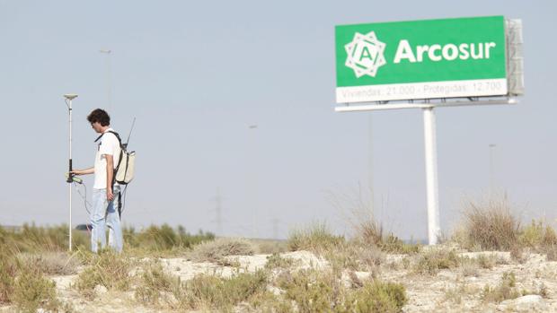 Un topógrafo, trabajando a pie de campo en terrenos de Arcosur, la gran zona de expansión urbana desarrollada en el último decenio en Zaragoza capital