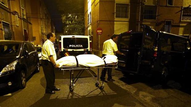 Los servicios funerarios trasladan el cadáver de la víctima, anoche, en Puente de Vallecas