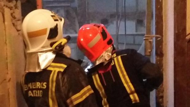 Los bomberos municipales acceden al interior de la vivienda, en la calle Lagasca