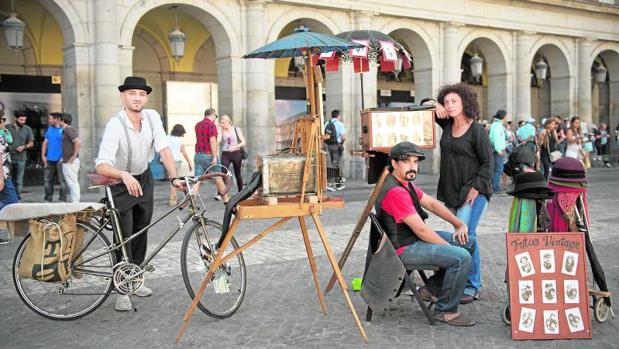 Alberto Cañizares, Héctor Gomilla y Eva Setién, en la Plaza Mayor; a la derecha, los retratos de época