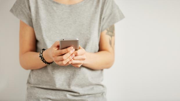 Uma mujer consulta su teléfono móvil en una imagen de archivo