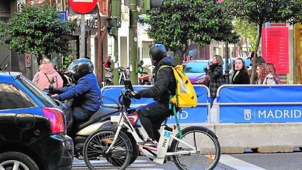 Un trabajador de una empresa de reparto a domicilio, con una bicimad, por Gran Vía, el jueves