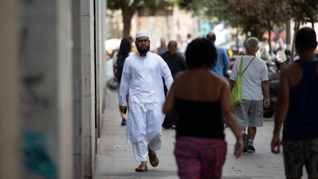 Un inmigrante pasea por las calles de la Raval