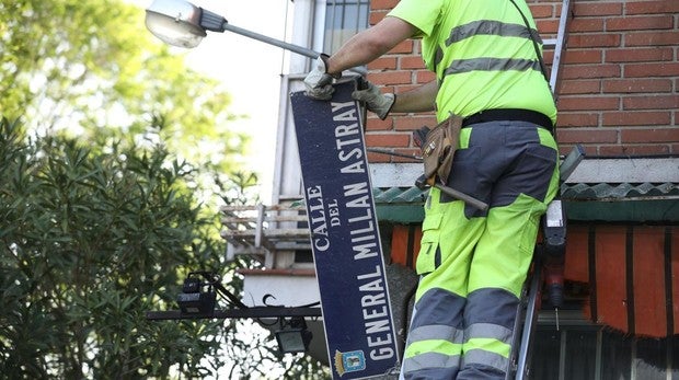 Un operario retira la placa de la calle de Millán Astray