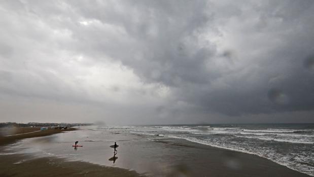 El cielo desde una playa de Valencia esta mañana, durante las lluvias por el temporal de gota fría