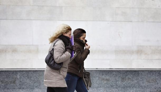Dos mujeres abrigadas se protegen de los efectos del frio
