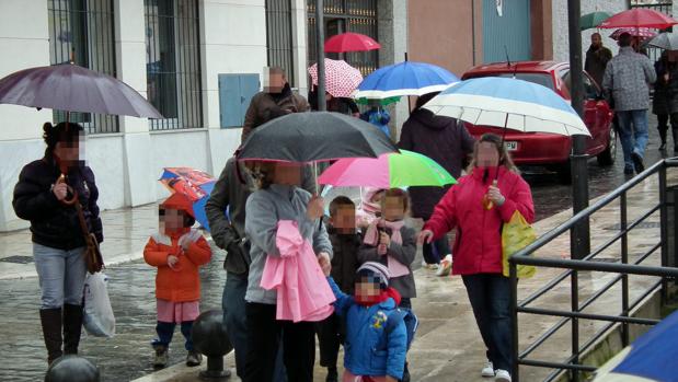 Un grupo de niños con sus madres a la salida de una escuela