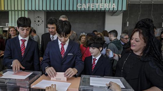 Jóvenes acuden a votar en un colegio electoral de Valencia