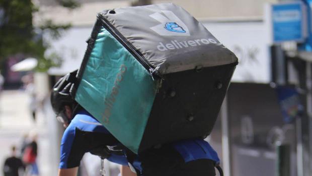 Un repartidor de Deliveroo lleva mercancía a un cliente en su bicicleta