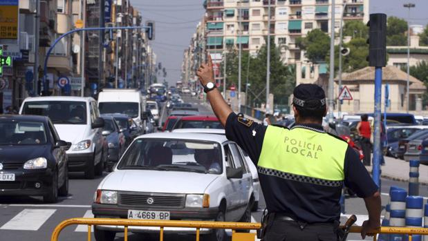 Imagen de un policía local dando indicaciones en Alicante