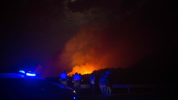 Policías y ciudadanos observan el fuego del incendio de Gran Canaria en Valleseco