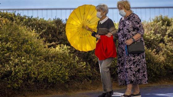 Two women walking with a mask