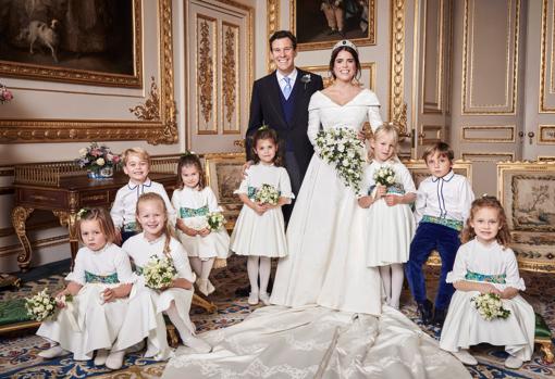 Los recién casados con el cortejo nupcial de damitas y pajes de honor