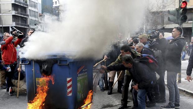 Varisos ganaderos prenden fuego a un contenedor de basura durante una protesta de ganaderos contra la reforma fiscal y de las pensiones ante el Ministerio de Agricultura en Atenas