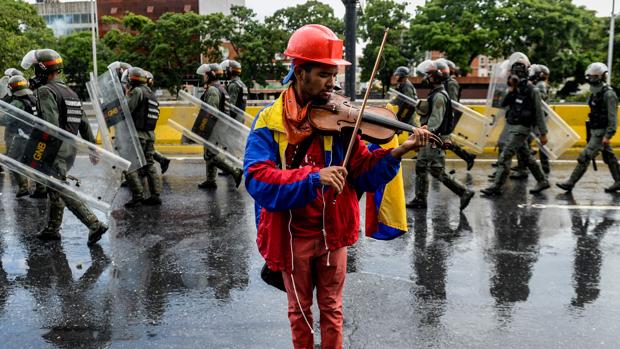 Willy Arteaga, toca el violín durante una protesta en una imagen de archivo