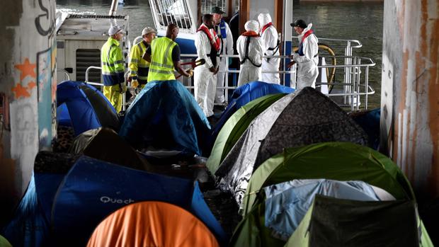 Los trabajadores llegan para limpiar el campamento improvisado de inmigrantes Millenaire a lo largo del Canal de Saint-Denis cerca de Porte de la Villette