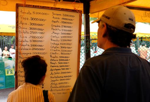 Dos personas comprueban los precios de distintos productos en un mercado de Caracas