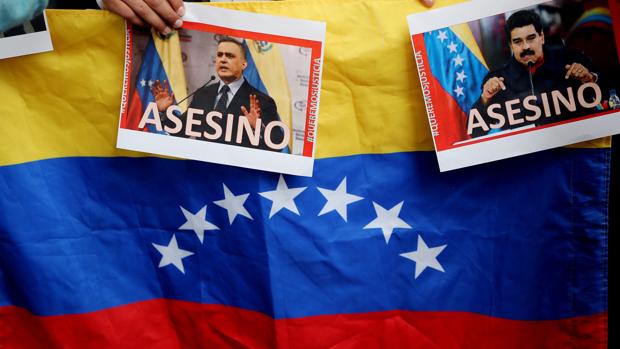 Vista de fotografías del presidente de Venezuela Nicolás Maduro y del fiscal general Tarek Saab en las que se lee la palabra «Asesino»