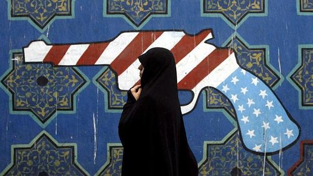 Una mujer iraní pasa frente a un mural antiamericano en Teherán