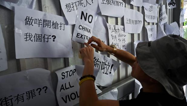 Un hombre pega hoy en Hong Kong un cartel de protesta contra la ley de extradición a China