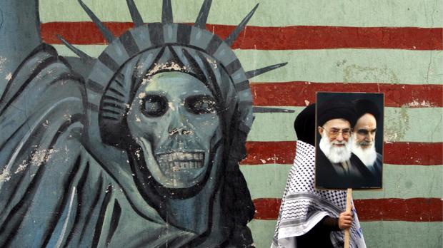 Una persona pasa junto a un mural antiestadounidense en Teherán