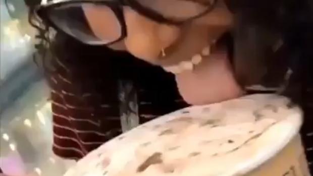 Una joven lame helado de un supermercado