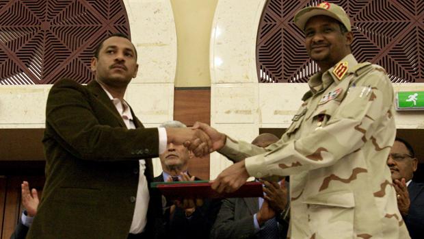 El vicepresidente de la junta militar, Mohamed Hamdan Dagalo (derecha), estrecha la mano del líder de la oposición sudanesa, Ahmad al-Rabiah, tras firmar el acuerdo, hoy en Sudán