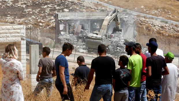 Vecinos de la zona palestina de Wadi Humus observan la demolición de una vivienda